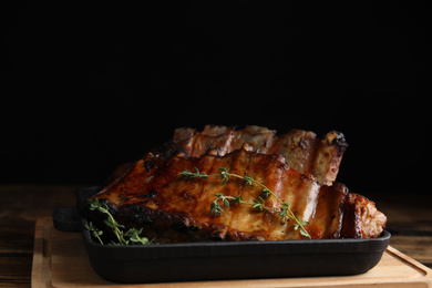 Photo of Tasty grilled ribs with thyme on wooden board