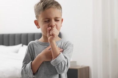 Photo of Sick boy coughing at home. Cold symptoms