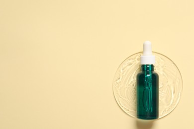 Photo of Bottle of cosmetic serum on beige background, top view. Space for text