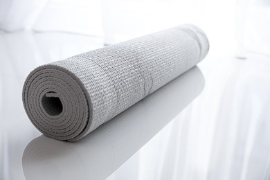 Photo of Rolled karemat or fitness mat on tiled floor