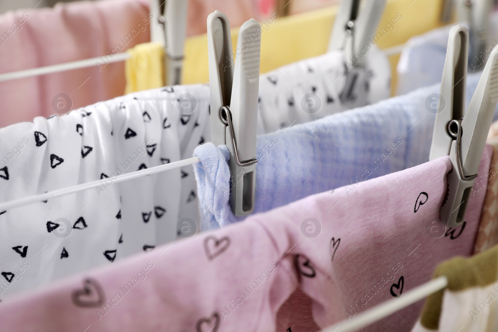 Photo of Clean laundry hanging on drying rack, closeup