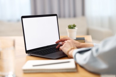 Young woman watching webinar at table in room, closeup