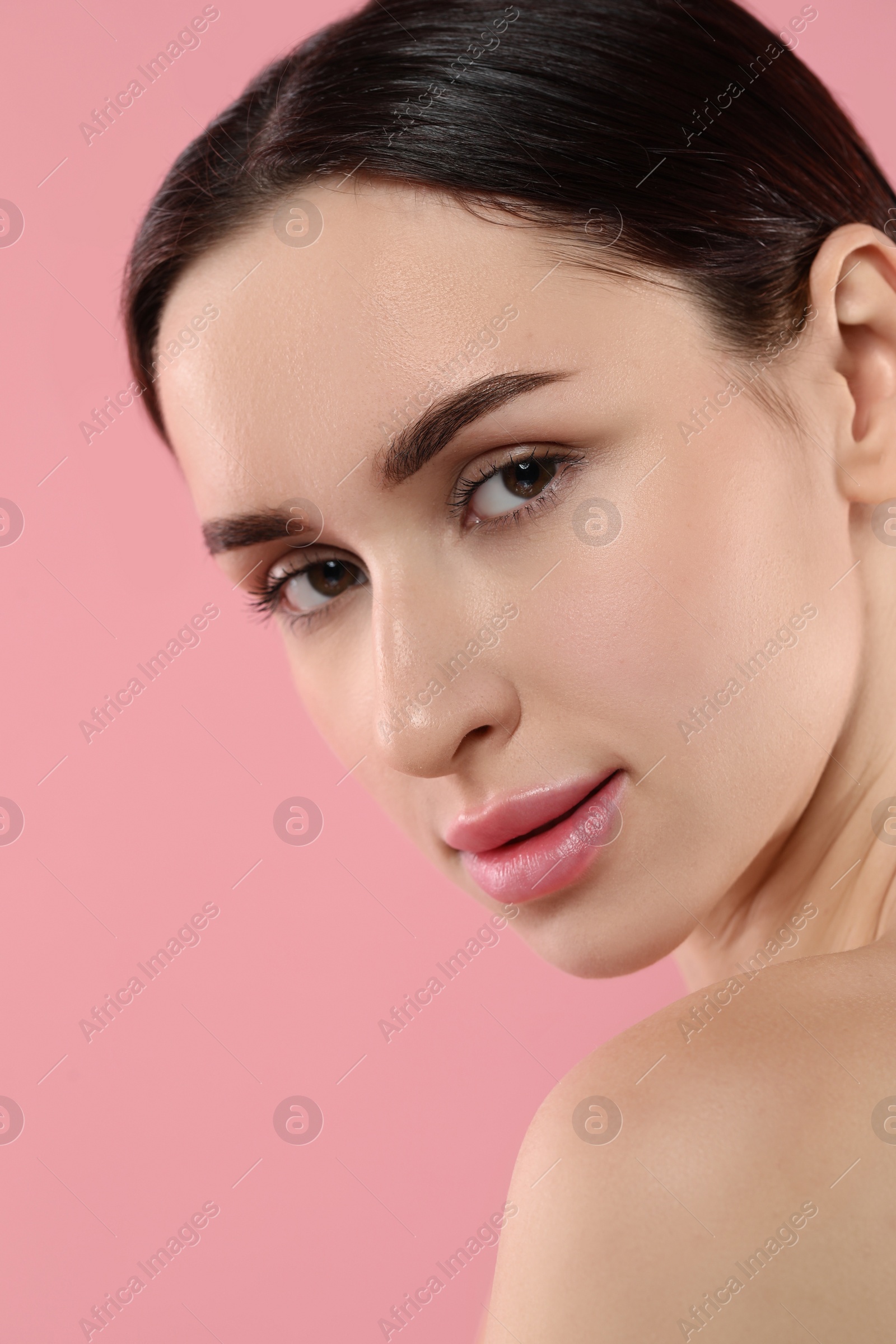 Photo of Portrait of beautiful young woman on pink background