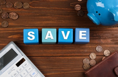 Photo of Flat lay composition with word SAVE made of colorful cubes on wooden background