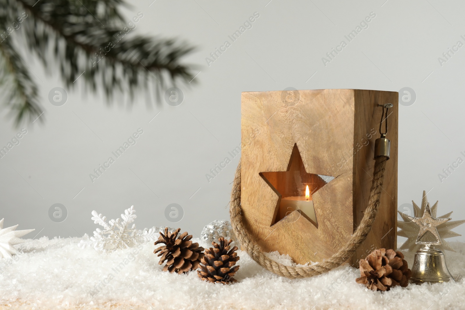 Photo of Composition with wooden Christmas lantern on snow against light grey background, space for text