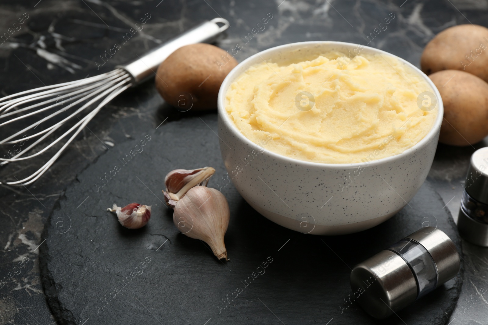 Photo of Bowl with tasty mashed potatoes on table