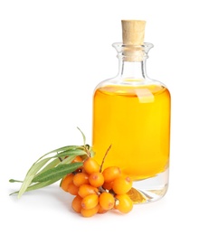 Photo of Natural sea buckthorn oil and fresh berries on white background