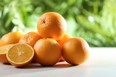 Photo of Ripe oranges on table against blurred background. Space for text