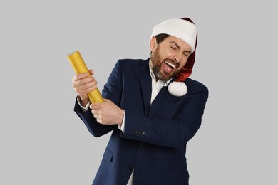 Photo of Emotional man with party popper on light grey background