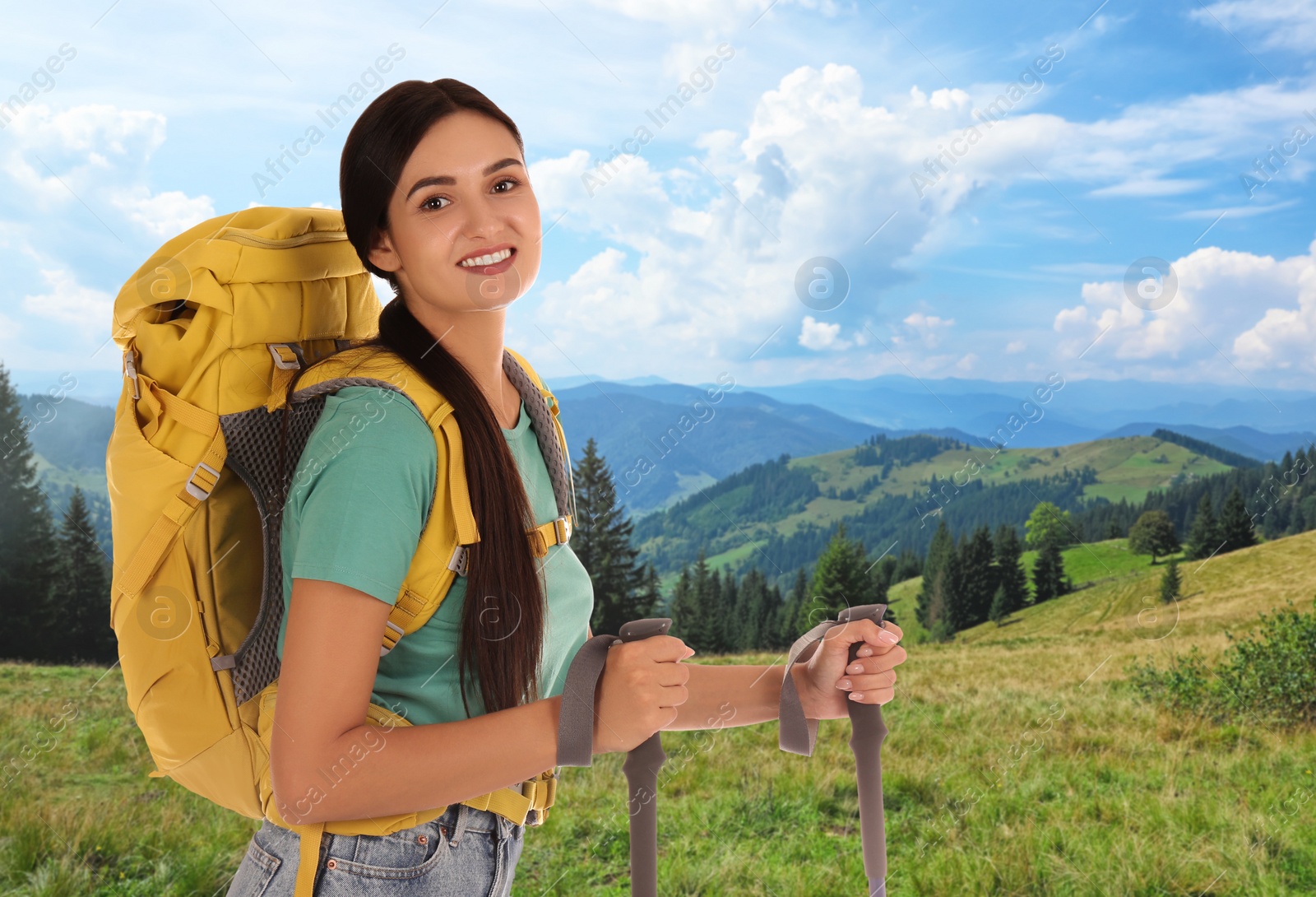 Image of Woman with backpack and trekking poles in mountains on sunny day