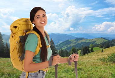 Woman with backpack and trekking poles in mountains on sunny day