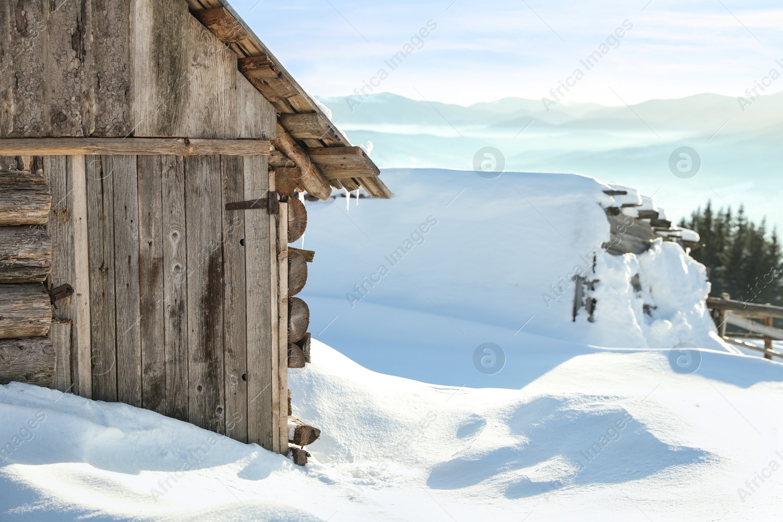 Photo of Wooden house with icicles on snowy day. Winter vacation