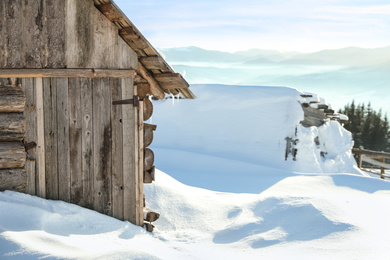 Photo of Wooden house with icicles on snowy day. Winter vacation