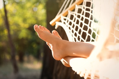 Photo of Woman resting in comfortable hammock at green garden, closeup