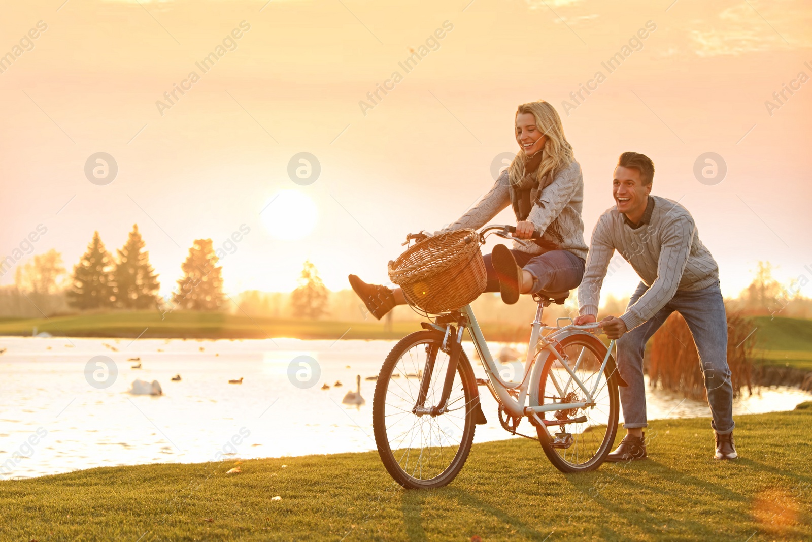 Photo of Happy young couple with bicycle having fun outdoors. Time for picnic