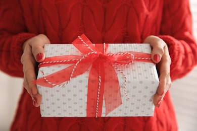 Photo of Woman holding white Christmas gift box, closeup