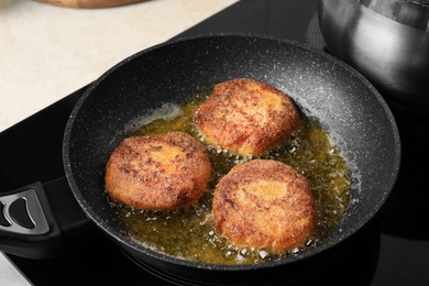 Photo of Cooking vegan cutlets in frying pan on stove, closeup