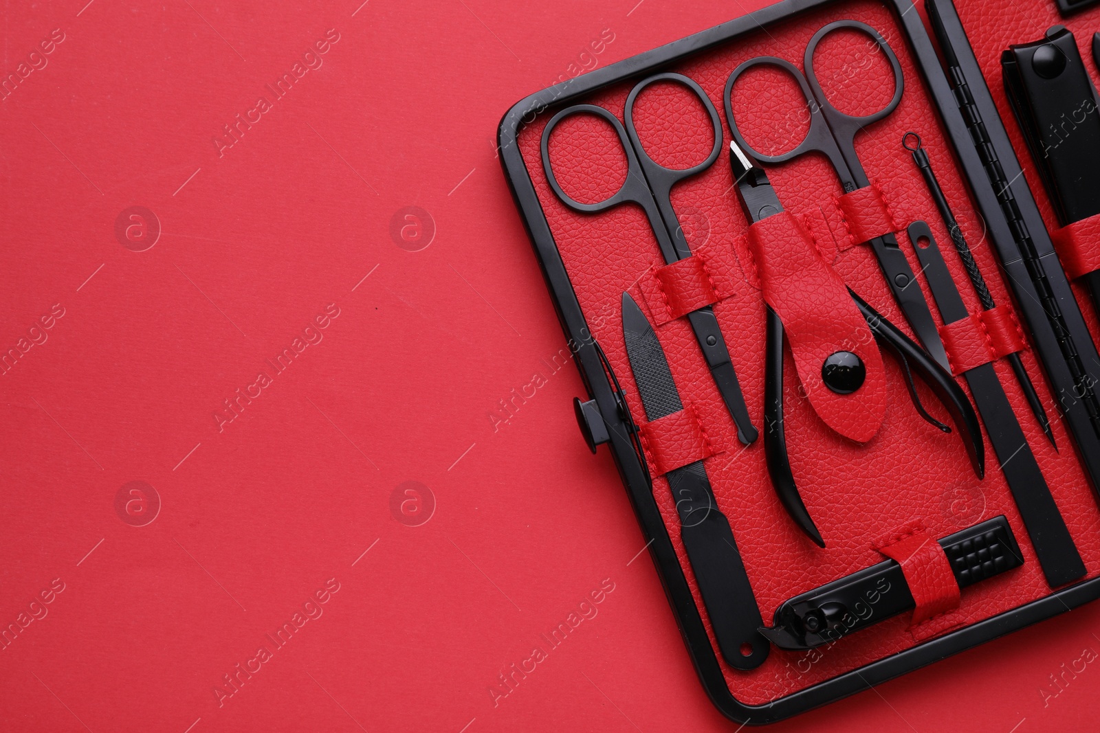 Photo of Kitpedicure tools on red background, top view. Space for text