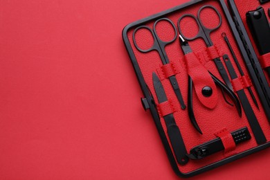 Photo of Kit of pedicure tools on red background, top view. Space for text