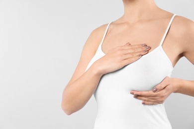 Photo of Woman checking her breast on white background, closeup