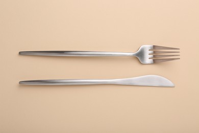 Photo of Stylish cutlery on beige table, top view