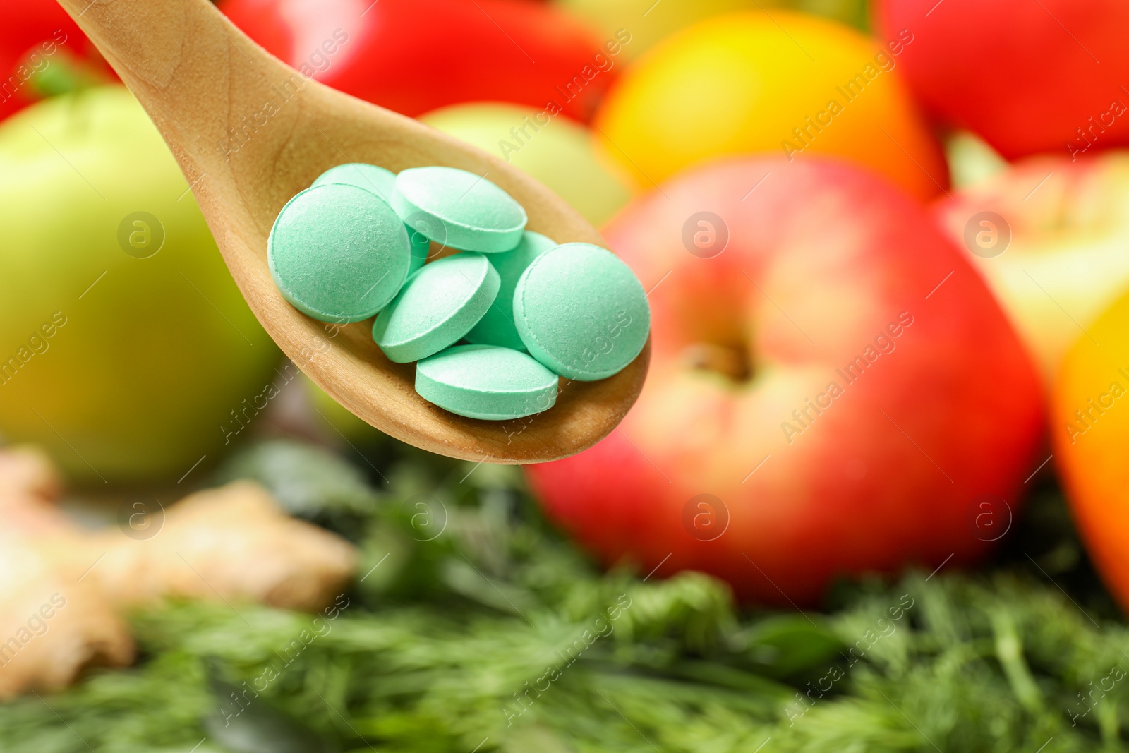 Photo of Dietary supplements in wooden spoon near products, closeup. Space for text