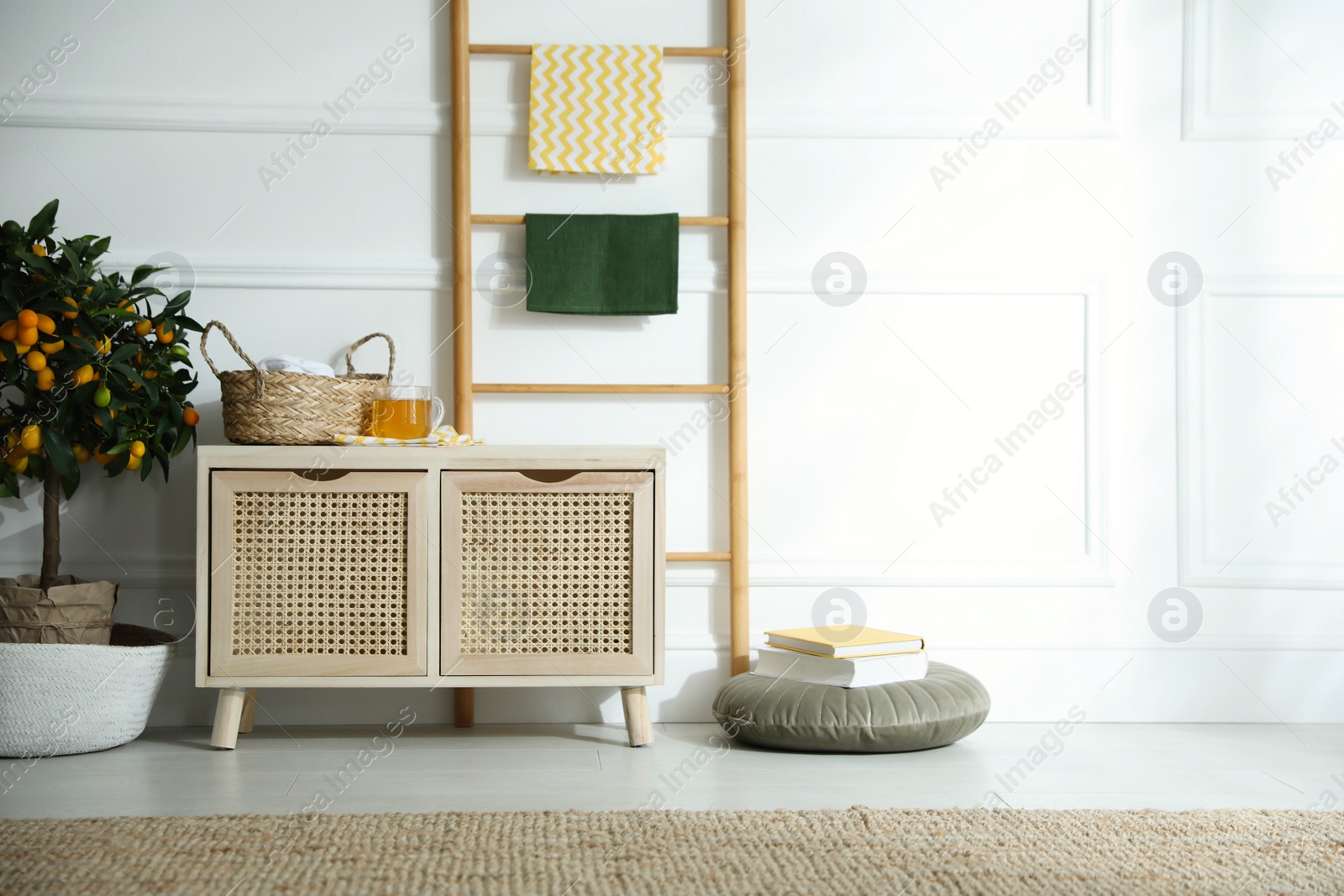 Photo of Wooden commode near white wall in room. Interior design