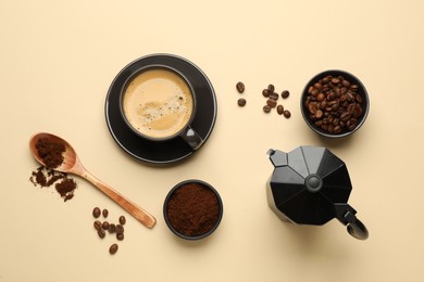Photo of Flat lay composition with ground coffee and roasted beans on beige background