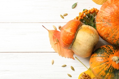 Different pumpkins on wooden background, flat lay composition with space for text. Autumn holidays