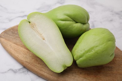 Photo of Fresh green chayote on light marble table, closeup