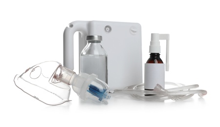 Photo of Modern nebulizer with face mask and medications on white background. Inhalation equipment