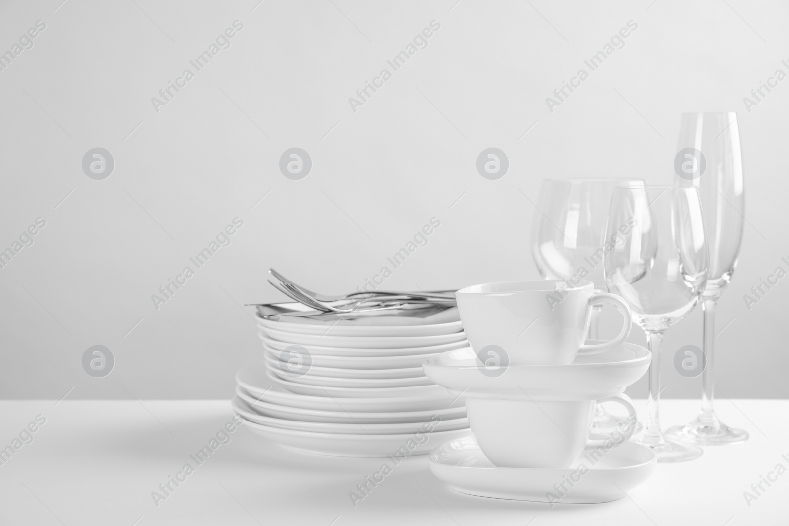 Photo of Set of clean dishes on white table