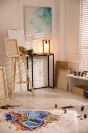 Photo of Wooden easel and abstract picture in art studio