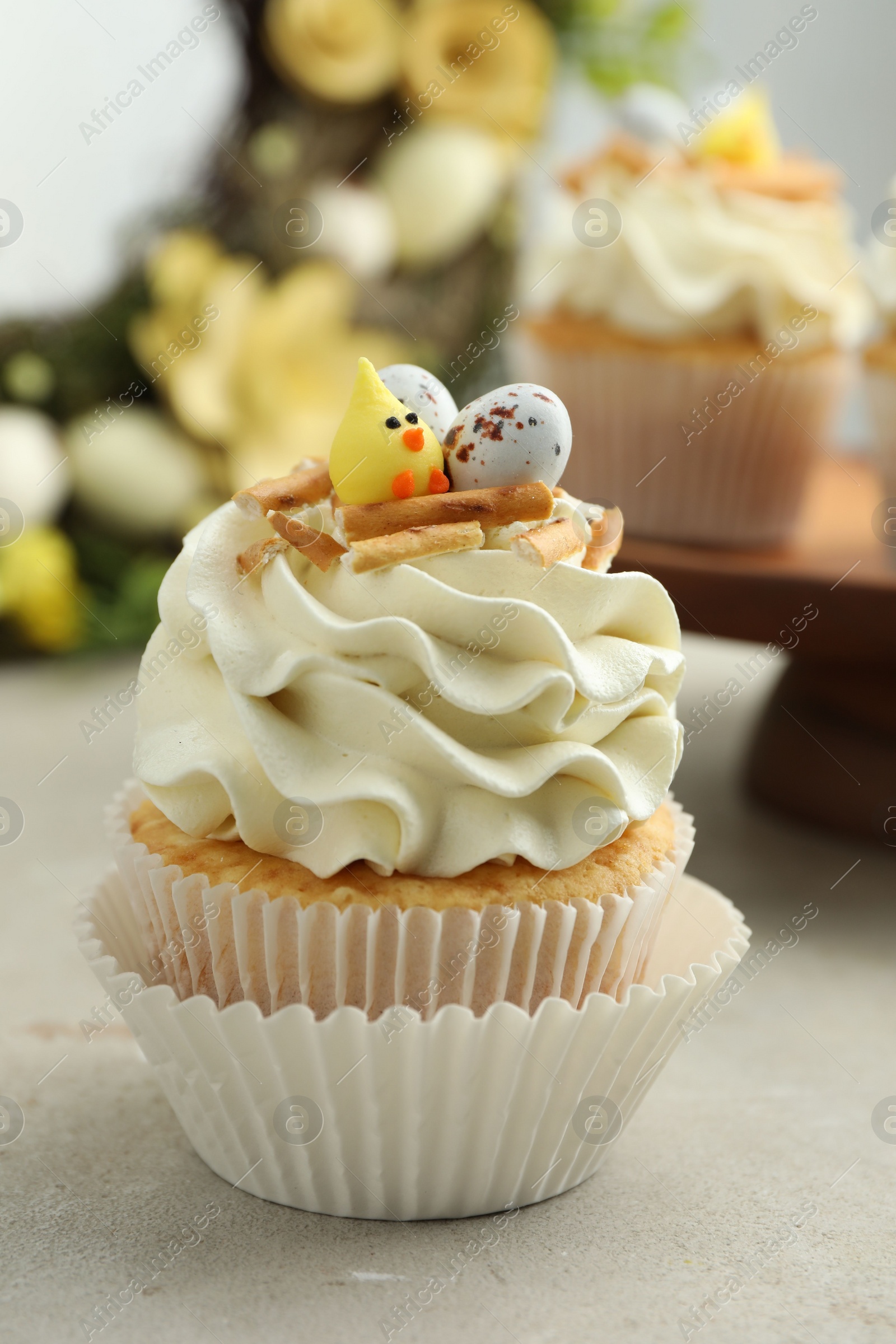 Photo of Tasty Easter cupcake with vanilla cream on gray table