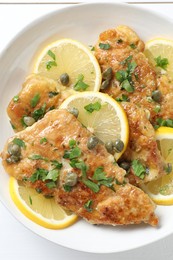 Delicious chicken piccata on white table, closeup