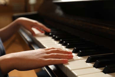 Photo of Little child playing piano, closeup. Music lesson