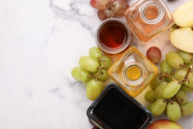 Photo of Different types of vinegar and ingredients on light marble table, flat lay. Space for text