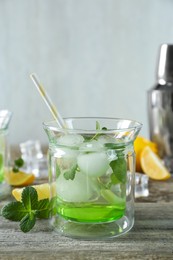 Photo of Delicious cocktail with mint and ice balls on wooden table