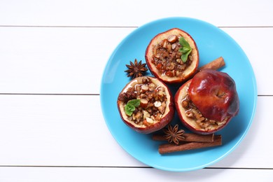 Photo of Tasty baked apples with nuts, honey, spices and mint on white wooden table, top view. Space for text