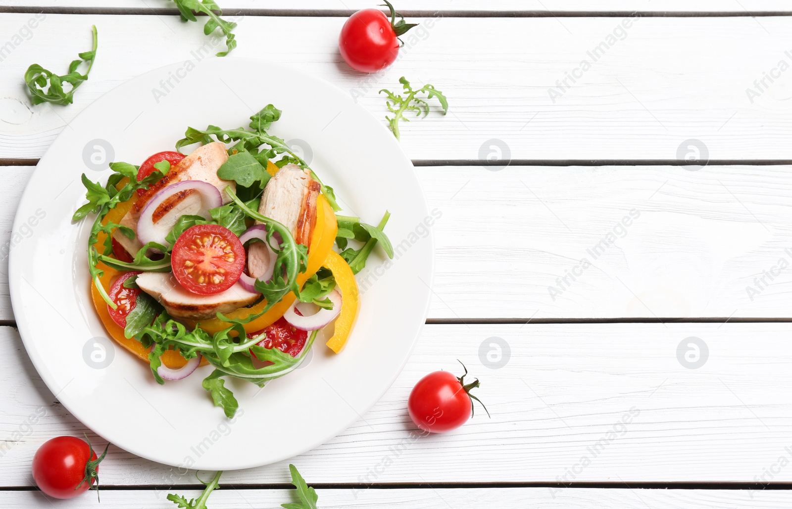 Photo of Delicious salad with chicken, vegetables and arugula on white wooden table, flat lay. Space for text