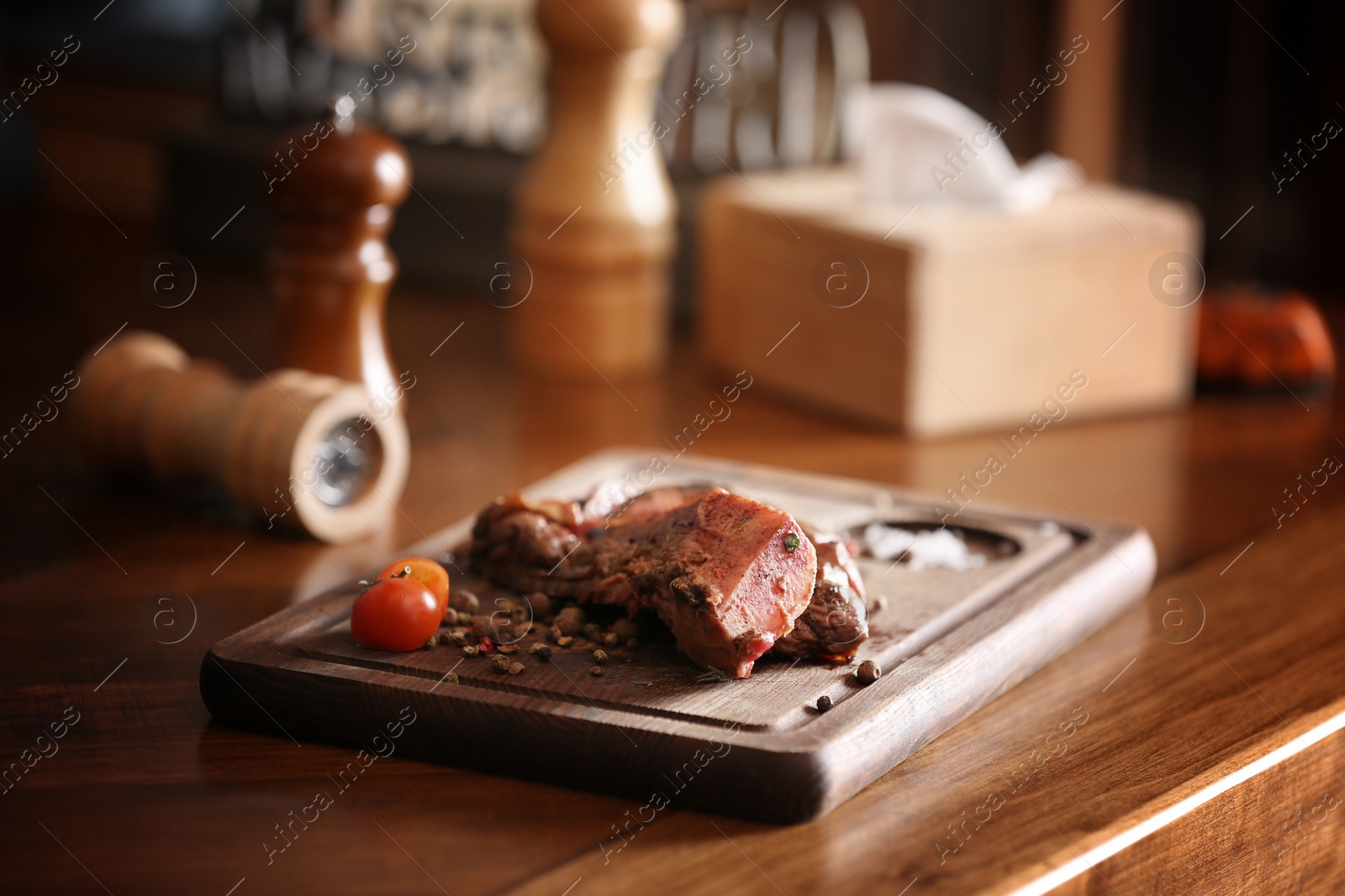 Photo of Tasty roasted meat served on wooden table. Cooking food