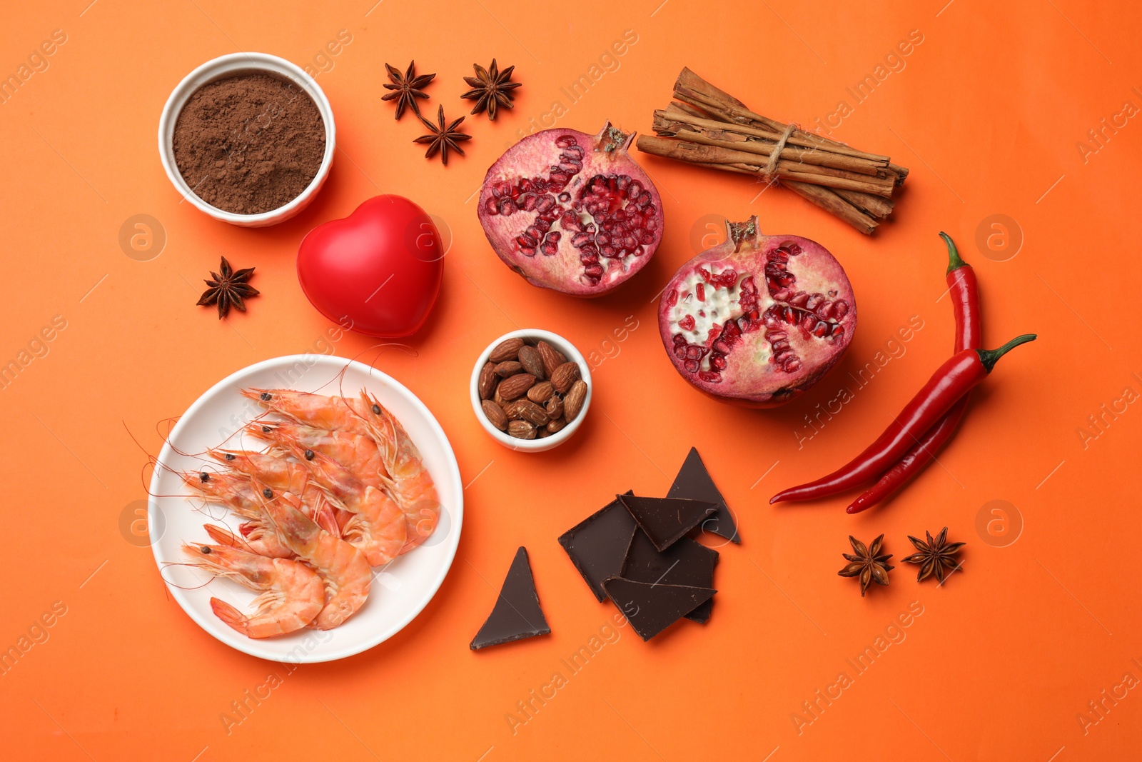 Photo of Natural aphrodisiac. Different products and heart model on orange background, flat lay