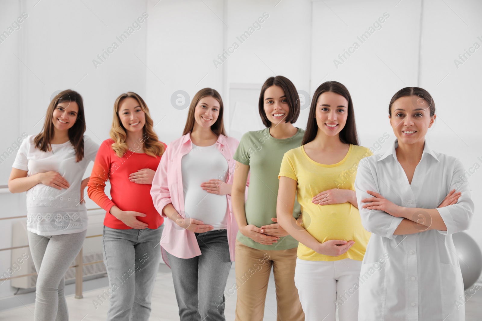 Photo of Group of pregnant women with doctor at courses for expectant mothers indoors