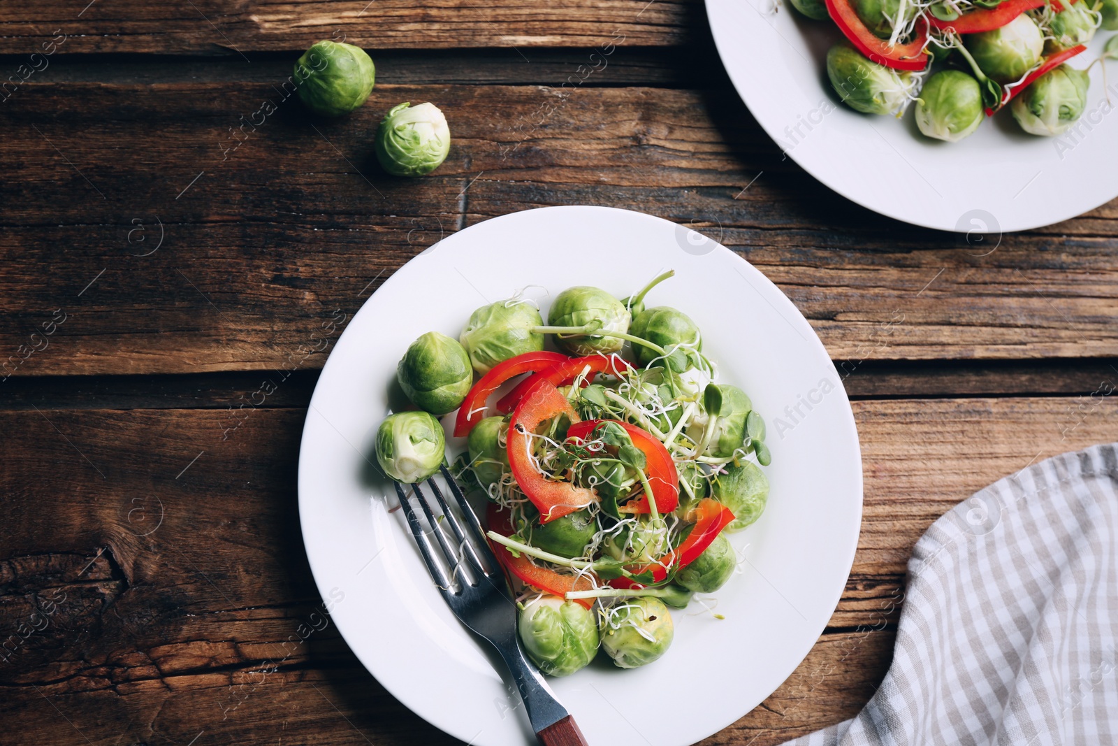 Image of Tasty salad with Brussels sprouts served on wooden table, flat lay. Food photography  