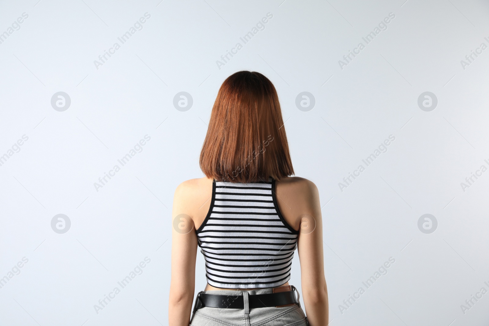 Photo of Girl wearing striped top on white background, back view