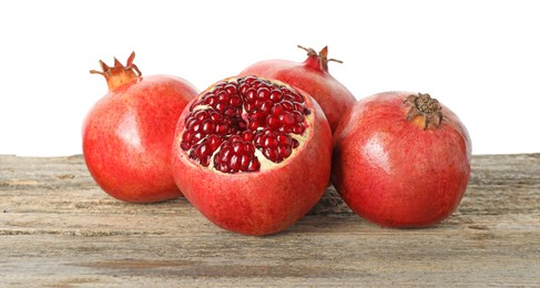 Photo of Fresh pomegranates on wooden table against white background