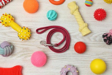 Photo of Flat lay composition with dog leash and toys on white wooden background