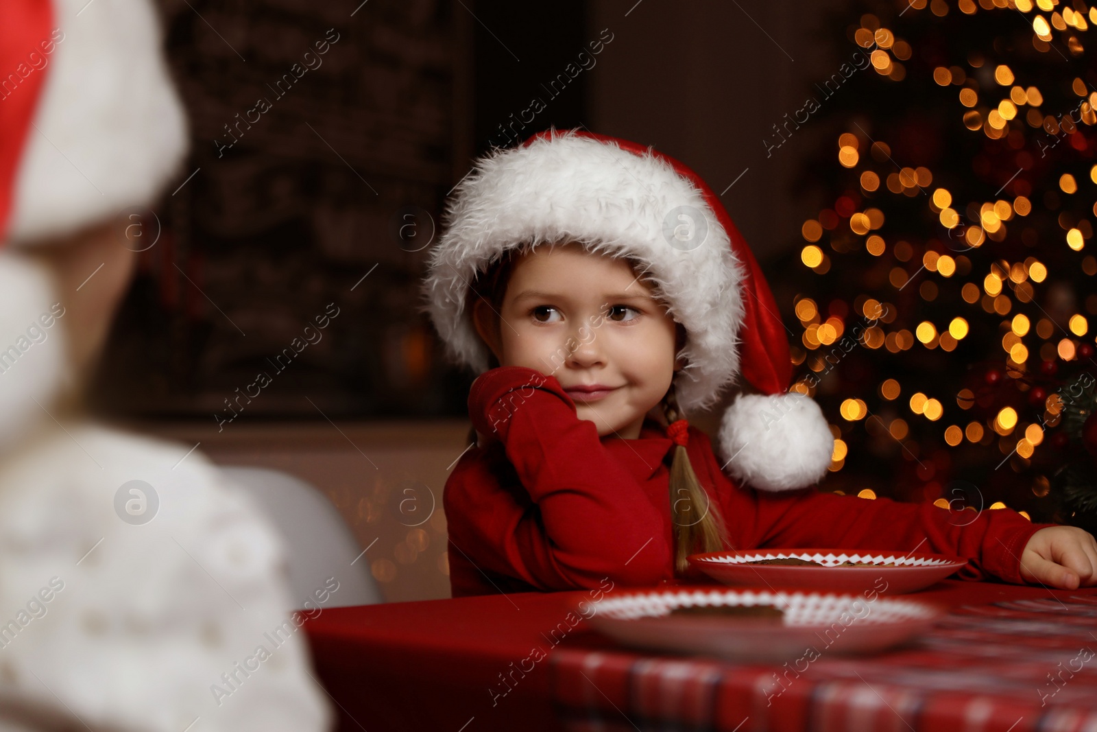Photo of Cute little children at table in dining room. Christmas time