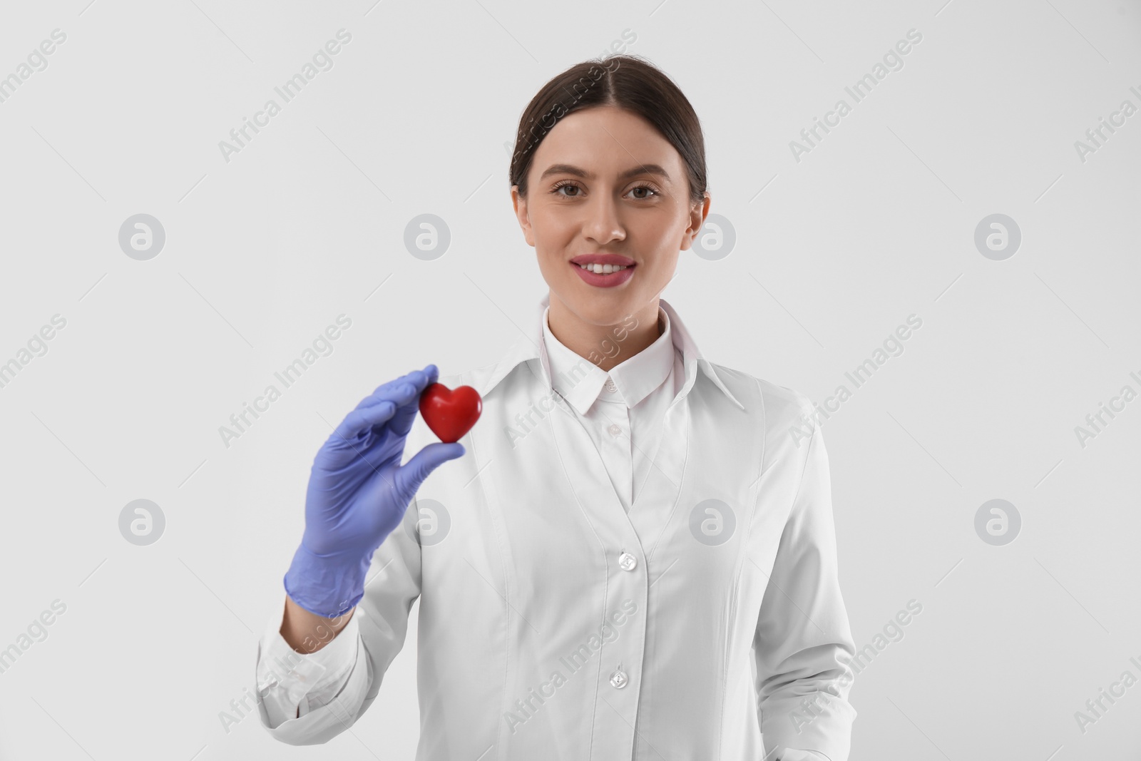 Photo of Doctor with red heart on white background. Cardiology concept