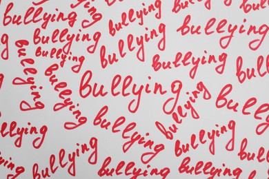 Photo of Words Bullying written on white background, top view